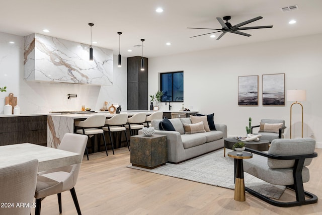 living room with light hardwood / wood-style floors and ceiling fan