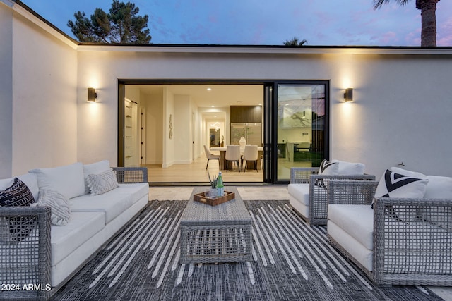 patio terrace at dusk featuring an outdoor hangout area