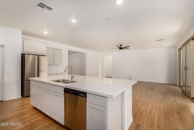 kitchen featuring stainless steel appliances, visible vents, a sink, and light wood-style flooring