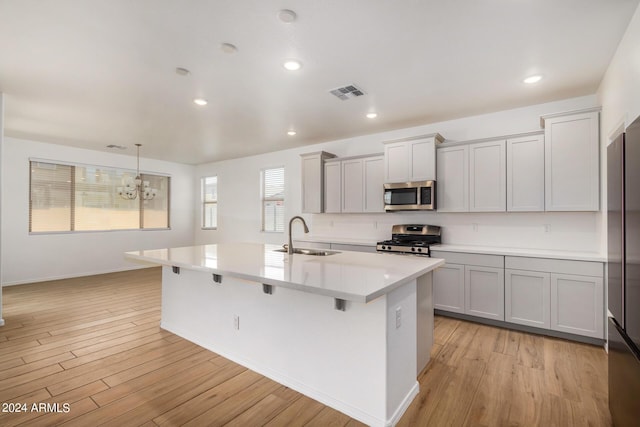 kitchen featuring stainless steel appliances, light wood-type flooring, a sink, and visible vents