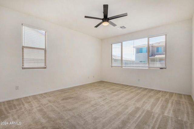 unfurnished room with baseboards, carpet, visible vents, and a ceiling fan