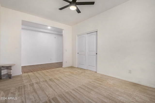 carpeted empty room with ceiling fan and baseboards