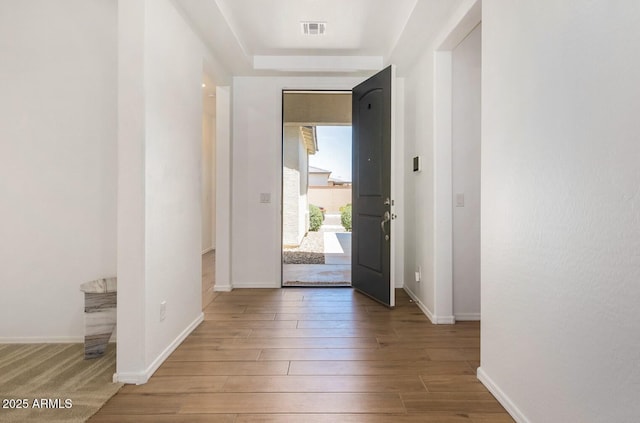 entryway featuring wood finished floors, visible vents, and baseboards