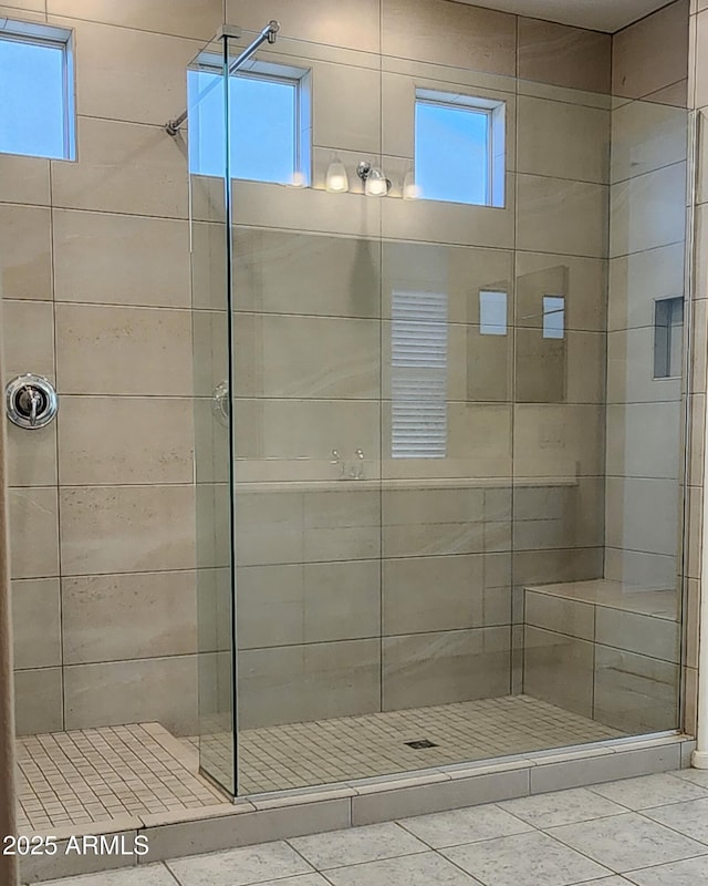 full bath featuring tile patterned flooring, a shower stall, and a wealth of natural light