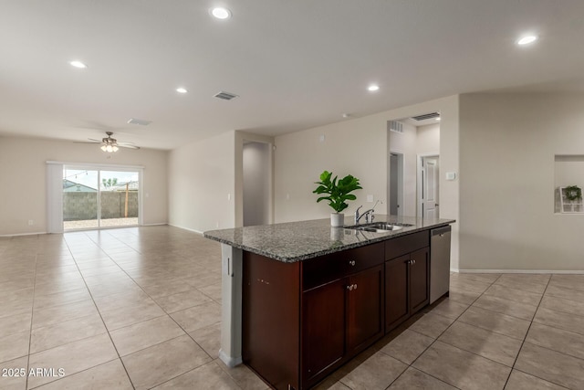 kitchen featuring a sink, dark stone counters, visible vents, dishwasher, and light tile patterned floors