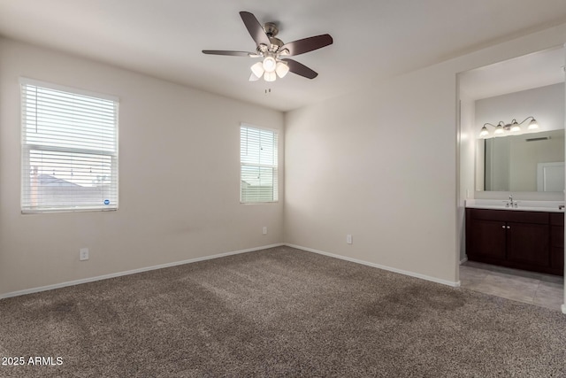 unfurnished bedroom with baseboards, light colored carpet, and a sink