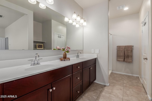 bathroom with tile patterned floors, a sink, visible vents, and double vanity
