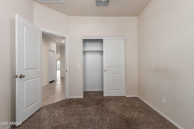unfurnished bedroom featuring baseboards, carpet flooring, visible vents, and a closet