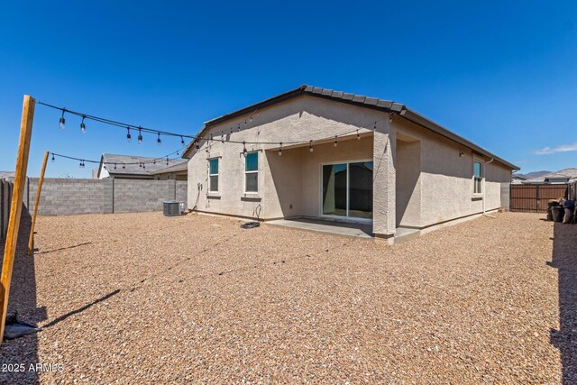 rear view of house with a patio area, a fenced backyard, central air condition unit, and stucco siding