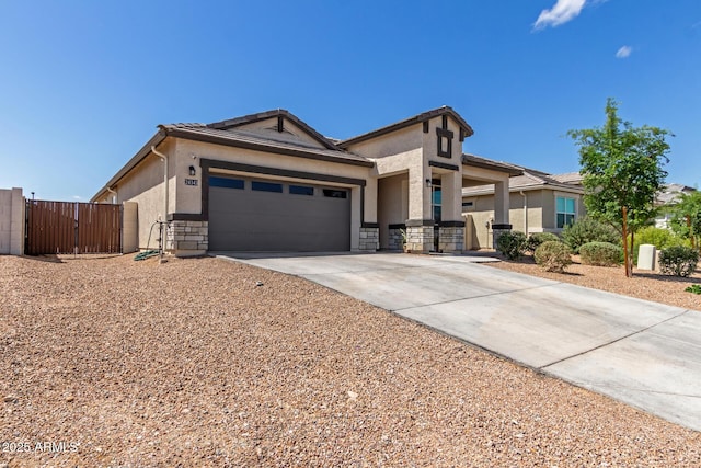 view of front of home with a gate, a tiled roof, stucco siding, concrete driveway, and a garage