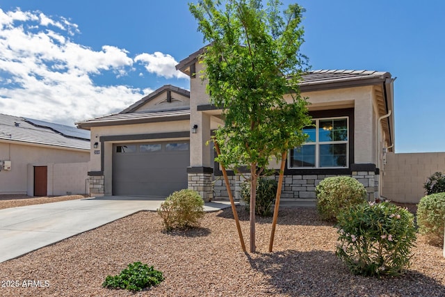view of front facade with stucco siding, a tile roof, an attached garage, and concrete driveway