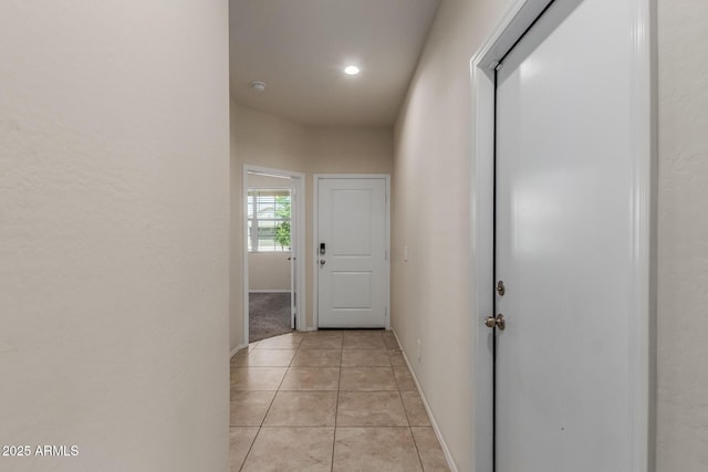 corridor with baseboards, recessed lighting, and light tile patterned floors