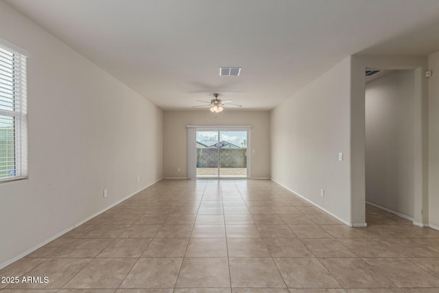 spare room with baseboards, a ceiling fan, visible vents, and light tile patterned flooring