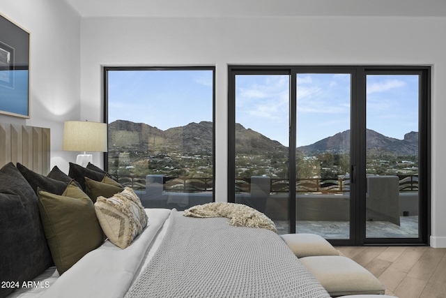 bedroom with a mountain view and light hardwood / wood-style floors