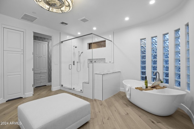 bathroom with plus walk in shower and hardwood / wood-style flooring