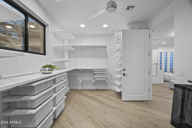 walk in closet with ceiling fan and light hardwood / wood-style floors