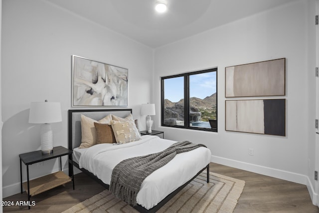 bedroom featuring a mountain view and dark wood-type flooring