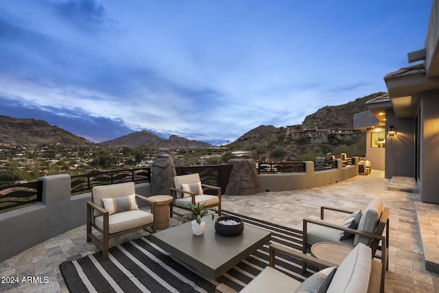 patio terrace at dusk with a mountain view and an outdoor hangout area