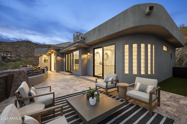 patio terrace at dusk with a mountain view and an outdoor hangout area