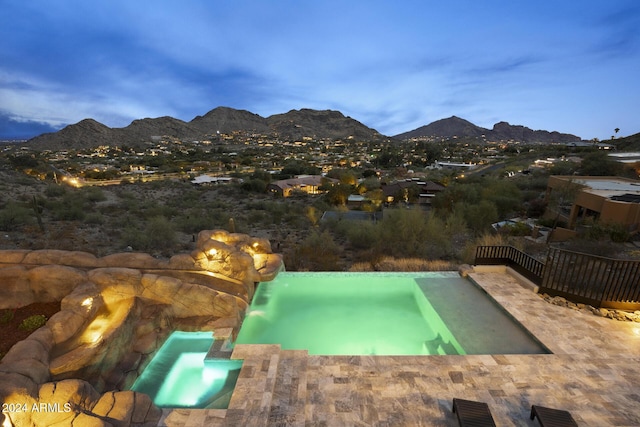 pool at dusk featuring a mountain view