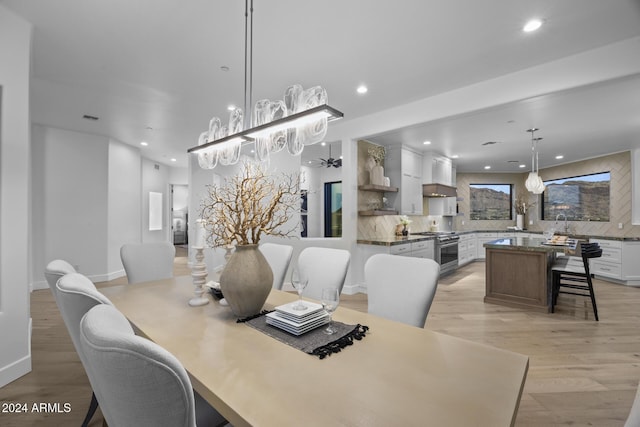 dining space with light wood-type flooring and ceiling fan