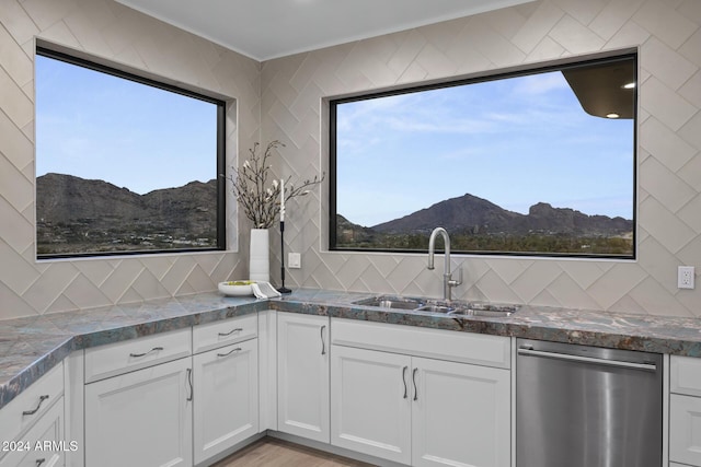 kitchen featuring a mountain view, dishwasher, sink, light wood-type flooring, and white cabinetry