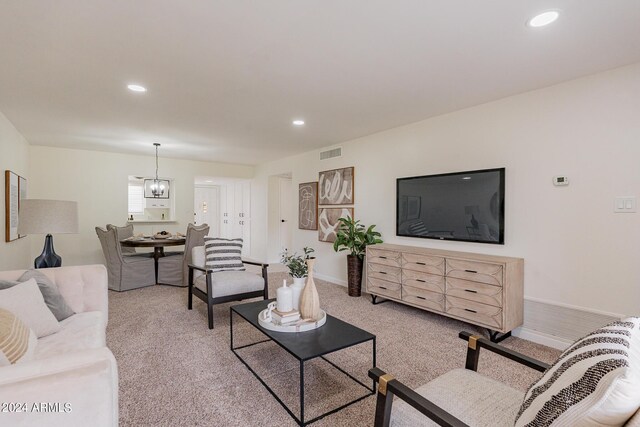 living room featuring an inviting chandelier and light carpet