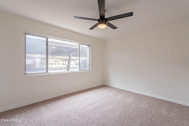 carpeted spare room featuring ceiling fan