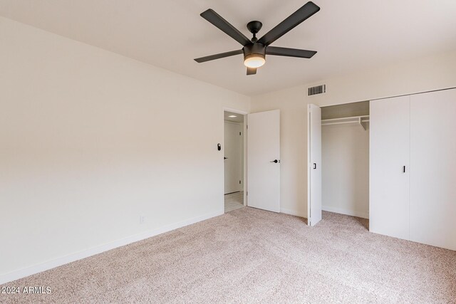 unfurnished bedroom with ceiling fan, light colored carpet, and a closet