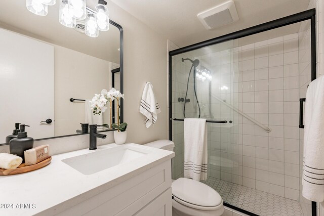 bathroom featuring an enclosed shower, vanity, a notable chandelier, and toilet