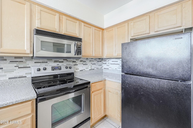 kitchen featuring light brown cabinetry, light tile patterned floors, stainless steel appliances, and tasteful backsplash