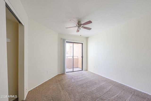 carpeted spare room featuring ceiling fan