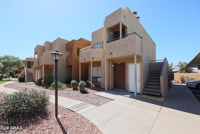 pueblo revival-style home with a balcony