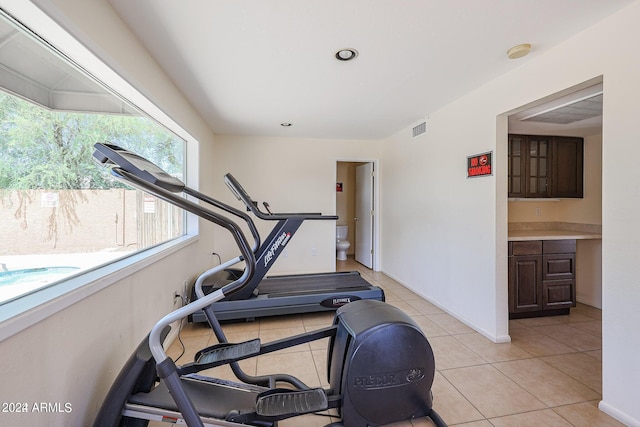 workout room featuring light tile patterned flooring