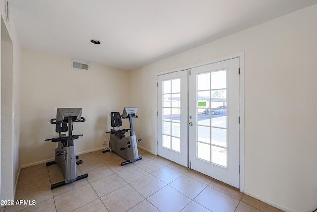 workout area featuring light tile patterned floors and french doors