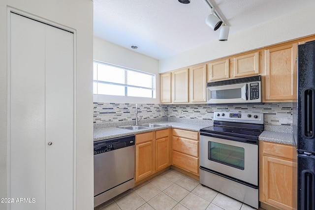 kitchen featuring appliances with stainless steel finishes, track lighting, light brown cabinetry, sink, and light tile patterned floors