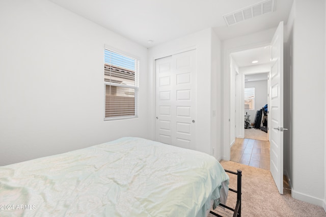 bedroom featuring light carpet and a closet