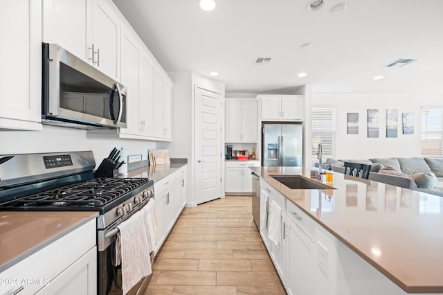 kitchen with white cabinetry, sink, and appliances with stainless steel finishes