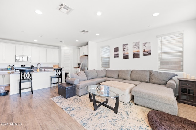 living room with sink and light hardwood / wood-style floors