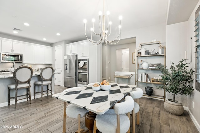 1941 W Yellowstone Way, Chandler, AZ 85248 - dining space with light wood-type flooring, recessed lighting, a chandelier, and baseboards