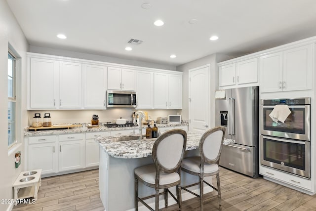 1941 W Yellowstone Way, Chandler, AZ 85248 - kitchen with stainless steel appliances, light wood-style flooring, white cabinetry, and recessed lighting