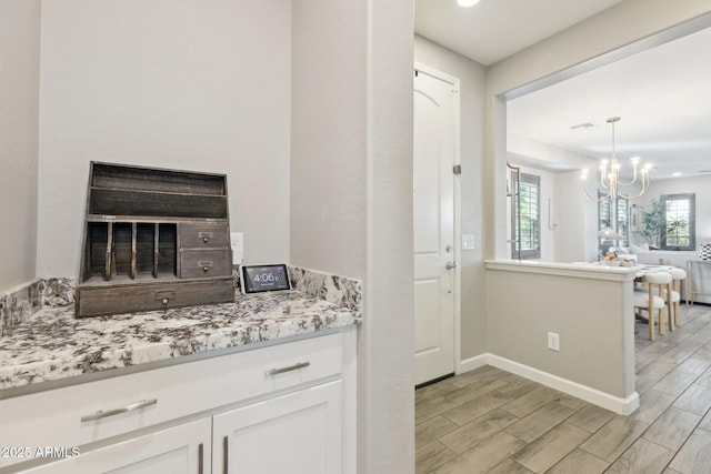 1941 W Yellowstone Way, Chandler, AZ 85248 - kitchen with wood tiled floors, a chandelier, open floor plan, white cabinets, and baseboards