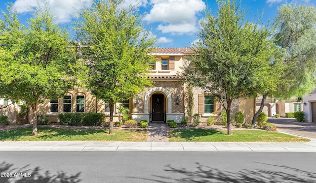 1941 W Yellowstone Way, Chandler, AZ 85248 - obstructed view of property with a tiled roof, stucco siding, a front yard, asphalt driveway, and brick siding