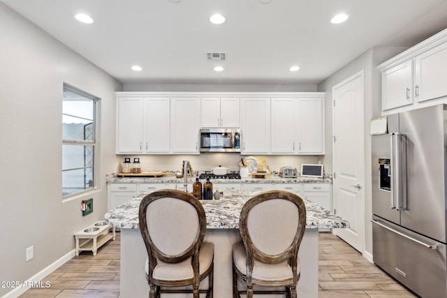 1941 W Yellowstone Way, Chandler, AZ 85248 - kitchen featuring stainless steel appliances, light wood-type flooring, white cabinets, light stone countertops, and recessed lighting