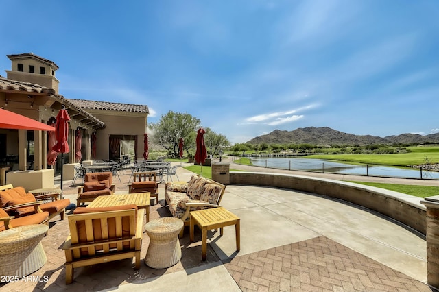 view of patio / terrace with a water and mountain view and a fireplace