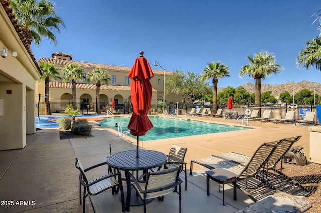 view of swimming pool featuring a mountain view and a patio area