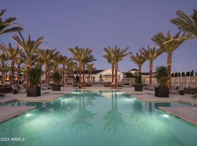 pool at dusk featuring a patio area