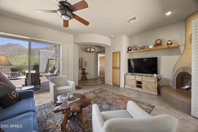 14007 E Lupine Ave, Scottsdale, AZ 85259 - living room with light tile patterned flooring, a ceiling fan, arched walkways, recessed lighting, and a fireplace