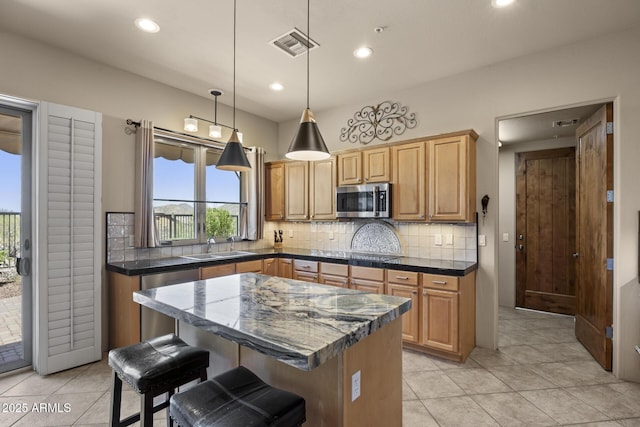 14007 E Lupine Ave, Scottsdale, AZ 85259 - kitchen featuring appliances with stainless steel finishes, decorative backsplash, recessed lighting, a kitchen breakfast bar, and light tile patterned floors