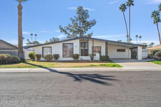 view of front of property with driveway, a carport, and stucco siding